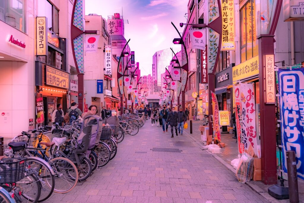 a group of people walking down a street next to tall buildings