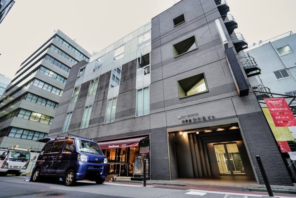 purple vehicle parked beside building during daytime