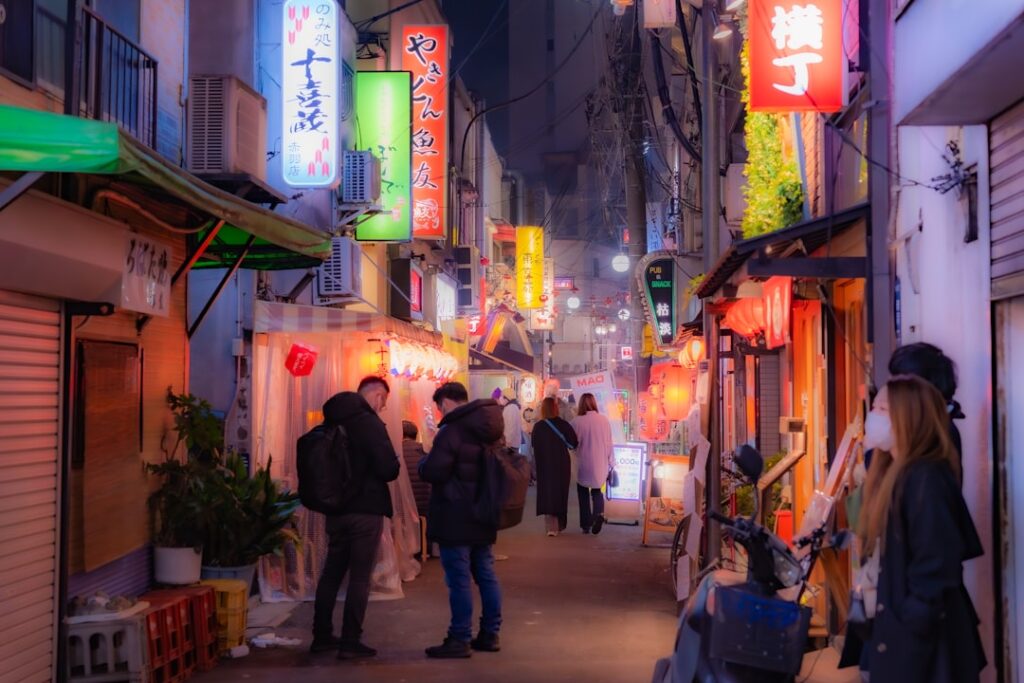 Nighttime alley in japan lit by neon lights.