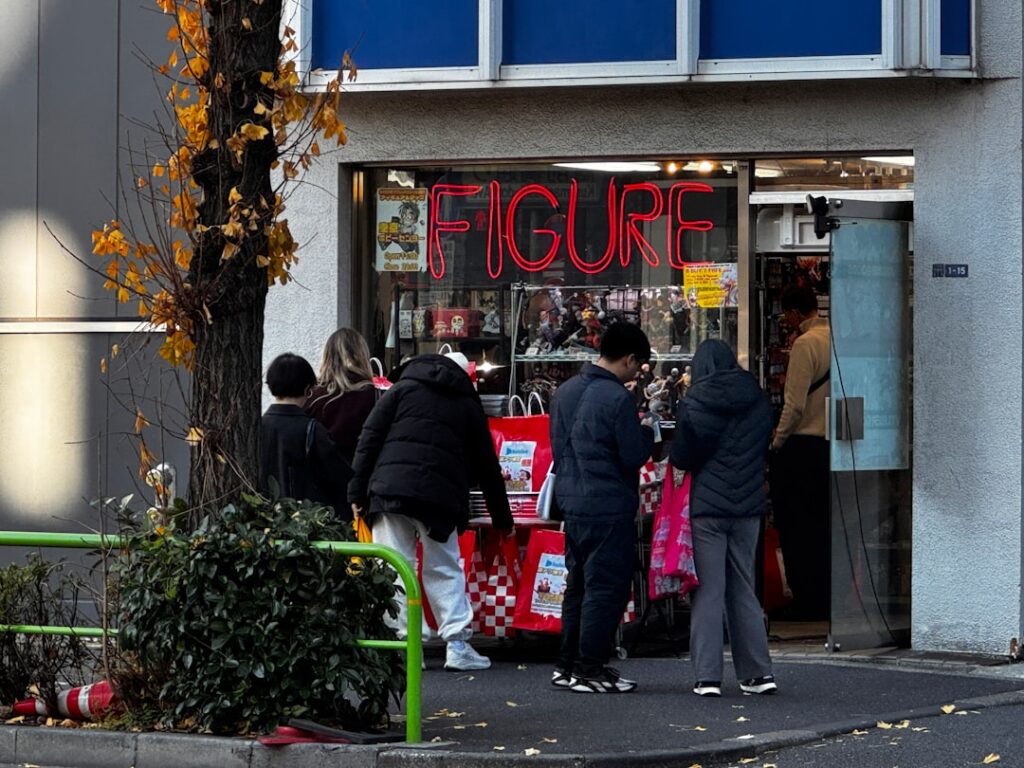 People browse outside a store with "figure" sign.